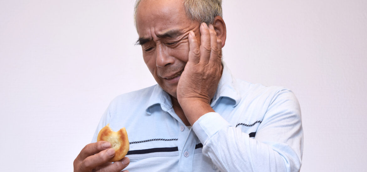 elderly male experiencing a tooth ache from eating sweets