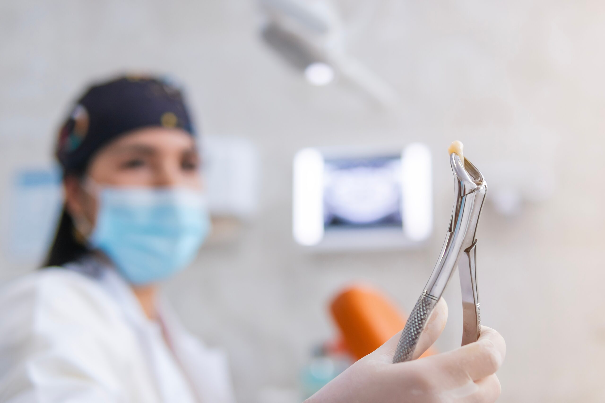 doctor holding up a pulled tooth in Fresno