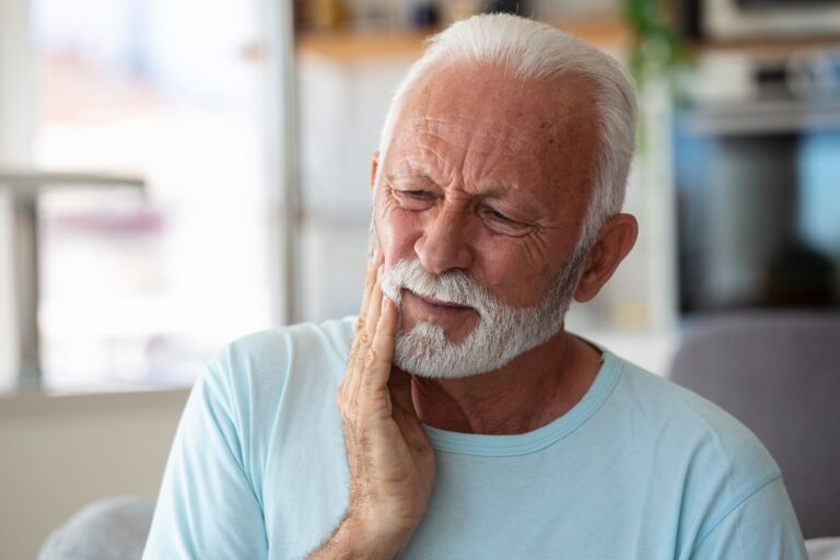 Senior Man Suffering From Terrible Strong Teeth Pain, Touching Cheek With Hand.
