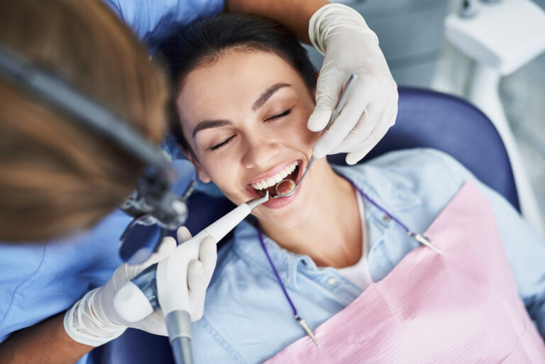 Top view portrait of beautiful lady with closed eyes and opened mouth sitting in dentist chair